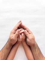 Father and child hands in a protective gesture on a white background photo