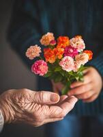 Generational connection. A child offering a colorful bouquet to an elderly person photo