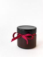 Elegant chocolate jar with red ribbon on white background photo