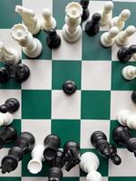 Dynamic chess game with vibrant black and white pieces on a checkered board photo