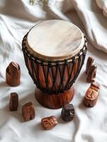 Top down view of a traditional African djembe drum surrounded by carved wooden figures photo