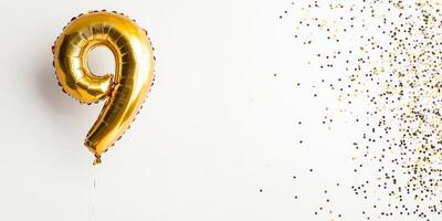 Festive golden number 9 balloon with colorful confetti for celebration and party decor photo