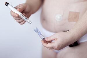 Person demonstrating insulin pump and injection in medical setting photo
