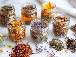 Colorful assortment of dried herbs and flowers in glass jars on marble surface photo