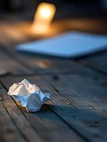 Symbolizing burnout with a single crumpled paper on a wooden table photo