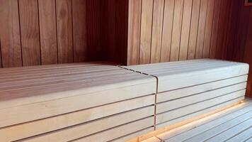 Wooden sauna showcases a view of snowy buildings and construction workers operating a crane in a valley surrounded by snowy pine forests, creating a serene winter atmosphere video