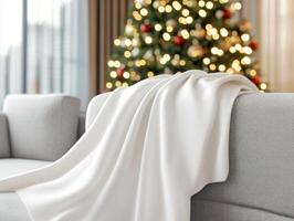Elegant white blanket mockup on sofa with cozy Christmas tree ambiance photo
