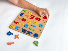 Child learning with colorful alphabet puzzle on white background photo