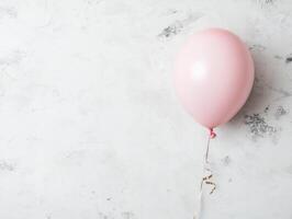 Minimalist birthday celebration flat lay featuring a single pink balloon on textured background photo