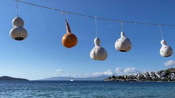 Handmade decorative lamps of calabash gourd hanging and swaying in the wind against the background of the sea and sky video