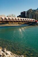 Peace Bridge with Bow River and part of the Calgary downtown in a sunny autumn day. photo