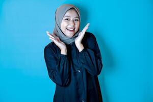 Asian woman wearing a hijab posing joyfullly with open hands near her face photo