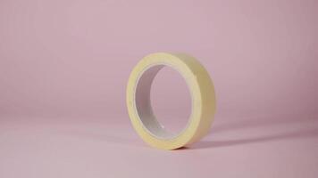 Yellow scotch roll turns and stops on a pink background video