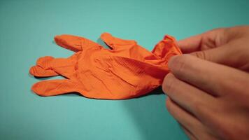 man puts on protective glove on turquoise background video