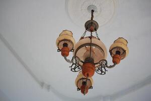 Elegant Vintage Chandelier with Ornate Design Hanging from a White Ceiling photo
