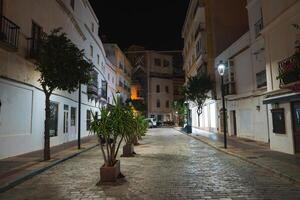 Nighttime View of a Narrow Street in Tarifa, Spain with Lights photo