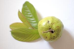 Pink guava with green leaves and slices isolated on white background, top view, flat. photo