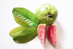 Pink guava with green leaves and slices isolated on white background, top view, flat. photo