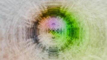 A blurry image of a circular object with a green, yellow and blue color video