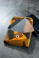 Handmade genuine leather products. Men's and women's wallet. Lying on a gray background. Top view of the object. photo