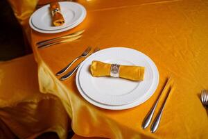 Elegant table setting with fork, knife and gold napkin photo