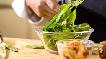 With the action of scissors snipping through crisp green vegetables, the chef expertly prepped a fresh and flavorful bowl of ingredients against a backdrop of delicious food. photo