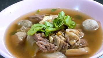 delicious beef stew with entrails and meatballs are decorated by green vegetable. Close up with studio light. photo