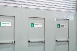 Steel fire doors exit are labeled with emergency exits for inform to people. Labelemergency exits with green letter and icon. photo