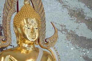 close up of golden Buddha statue is a stunning sight to behold. The intricate details and craftsmanship of the sculpture are clearly visible, showcasing the skill and talent of artist who created it. photo