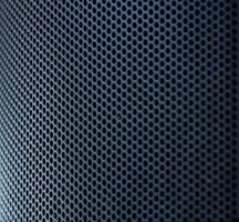 The close up photo of the modern black speaker and the metallic stand on a blurry background.