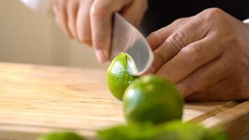 Chef using hands push and roll a lime to juice on a wooden chopping board before cutting and squeezing it. photo