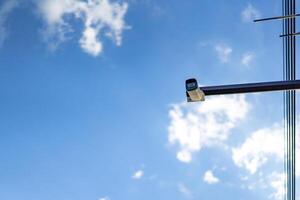 cctv camera is installed on the Metal stick that hung on to electric pole beside the street in village for monitoring and running safety system control in that area. photo