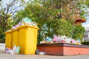 Garbage bins are overflowing since there are not enough receptacles and bins to handle the flow of waste for that area. photo