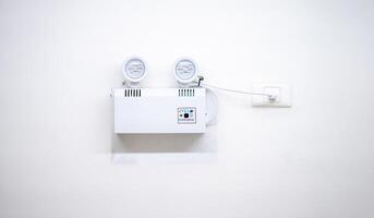 Automatic EMERGENCY LIGHT in hospital is charging and power pluging on the wall that ready to use when the power went out. photo