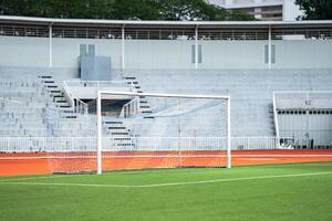 Goal area of artificial grass or turf court yard in front of an empty grand stand and entrance - exit main door. photo