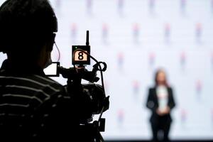 Asian man Videographer in backside are shooing and recording in Speech event on the stage. photo