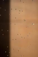 Abstract backgrond dropped water stop motion and dripping to the ground from Shower on blur orange brown background at outdoor light. photo