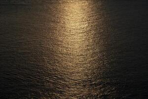 Close up to the texture of the sea surface with the abstract golden colour background in the twilight time. photo