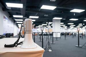 Two white - gray MEGAPHONE are laid on cream table in empty hall, ready to used for event corona virus vaccine booster in Bangkok, Thailand. photo