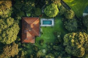 Aerial view of a house with a pool surrounded by lush greenery. photo