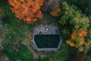 Aerial view of a stone pond in autumn forest. photo