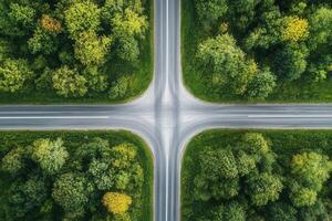 Aerial view of four-way intersection surrounded by lush green forest. photo