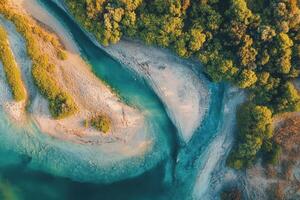 Aerial view of a meandering river flowing through lush green forest. photo