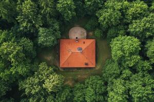 Aerial view of a house nestled in a lush green forest photo