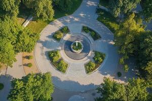 Aerial view of a circular park with a central fountain and lush greenery. photo