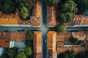 Aerial view of a city intersection with orange rooftops, green trees, and narrow streets. photo