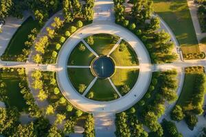 Aerial view of a circular park with pathways, trees, and a central fountain. photo