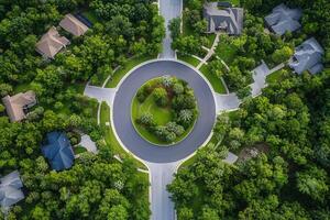 Aerial view of a residential roundabout surrounded by lush green trees and houses. photo