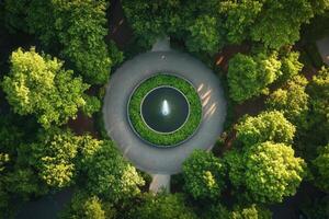 Aerial view of a circular fountain surrounded by lush green trees in a park. photo