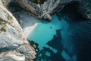 Secluded cove with turquoise water and white sand beach viewed from above. photo